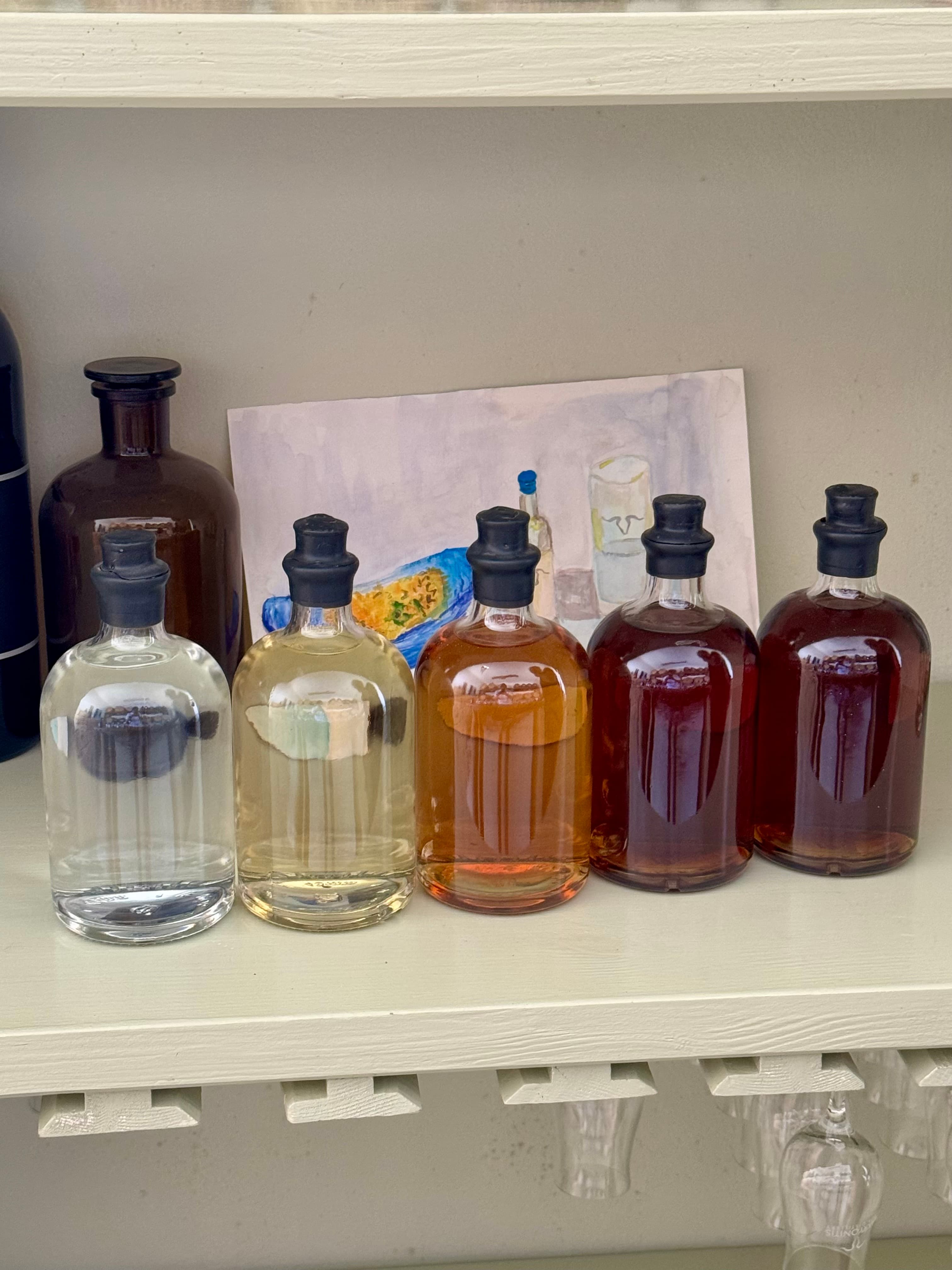 Bottles that show how the color of tsipouro changes depending on the length of aging.