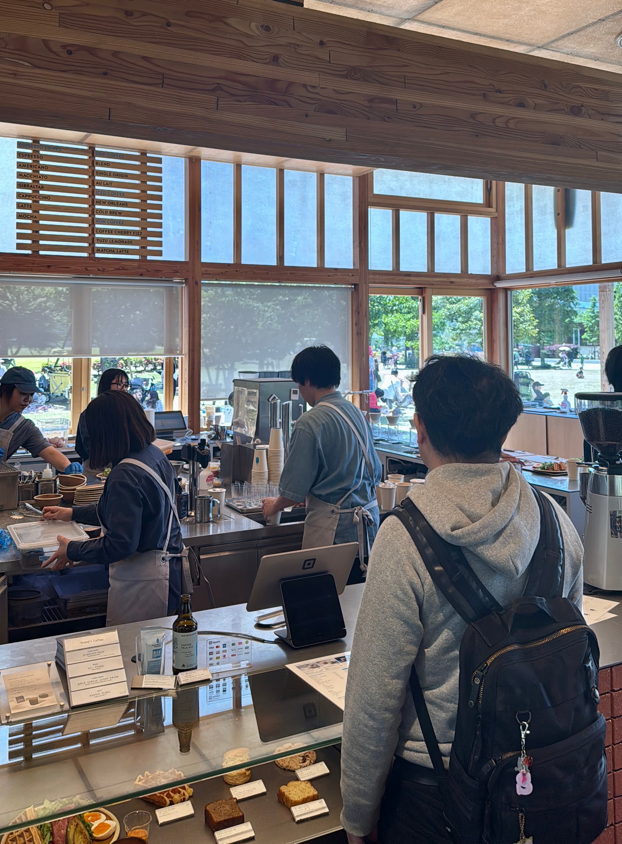 The interior of the bustling Blue Bottle Coffee in Toyosu Park.