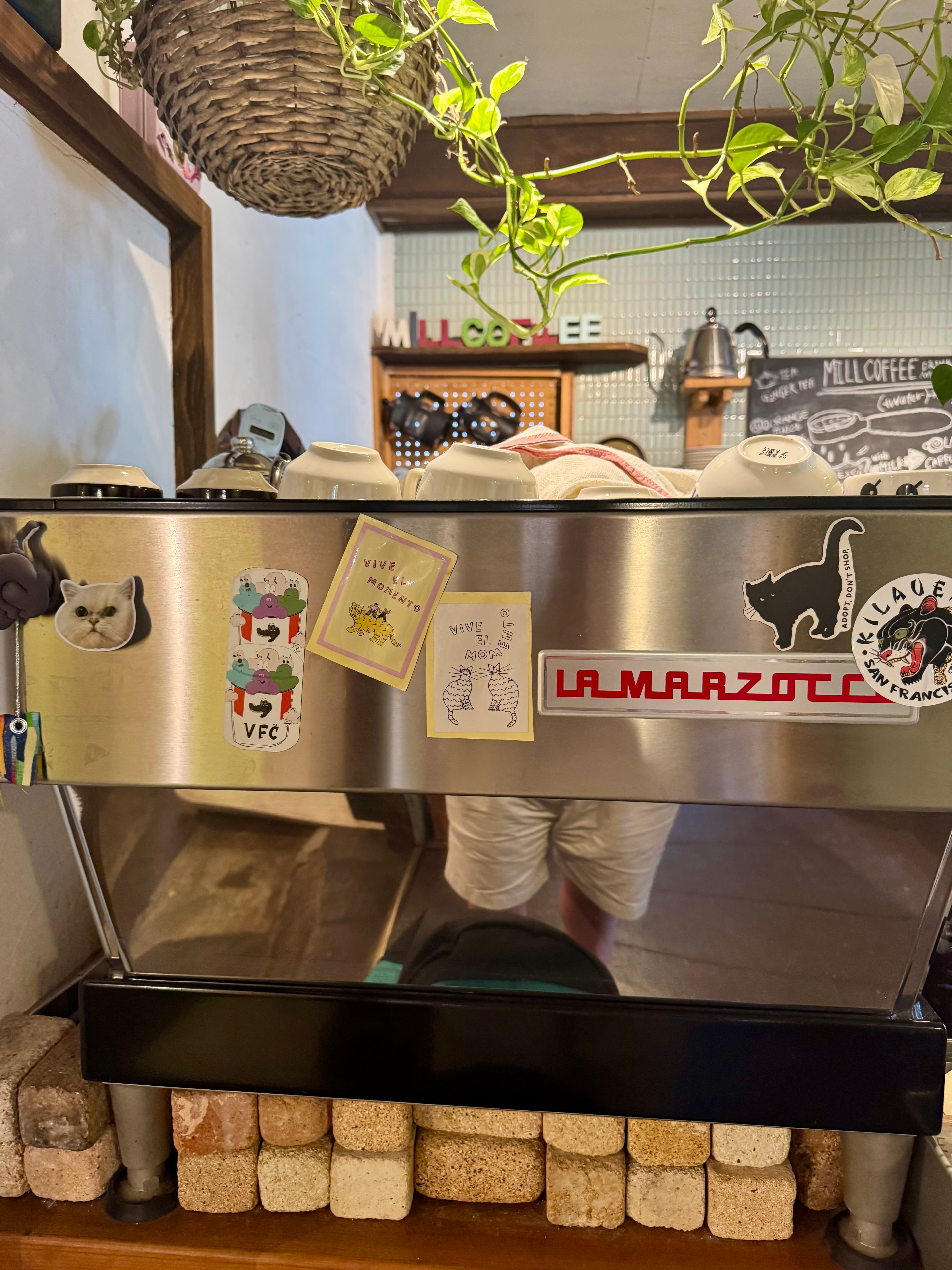 The coffee machine with the cute stickers at Mill Coffee & Stand.