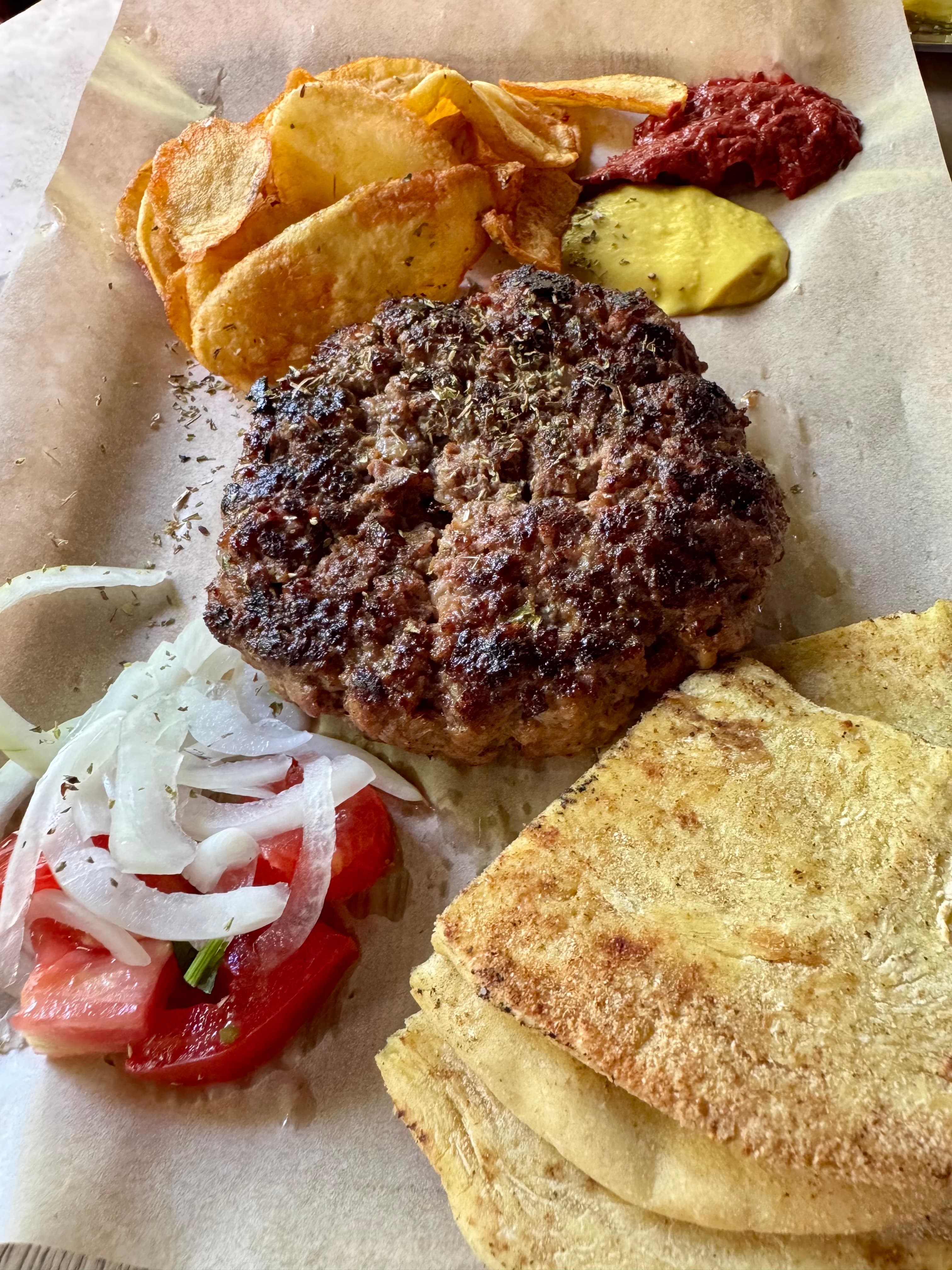 The 380-gram **bifteki (μπιφτέκι)** made from ground beef and lamb.