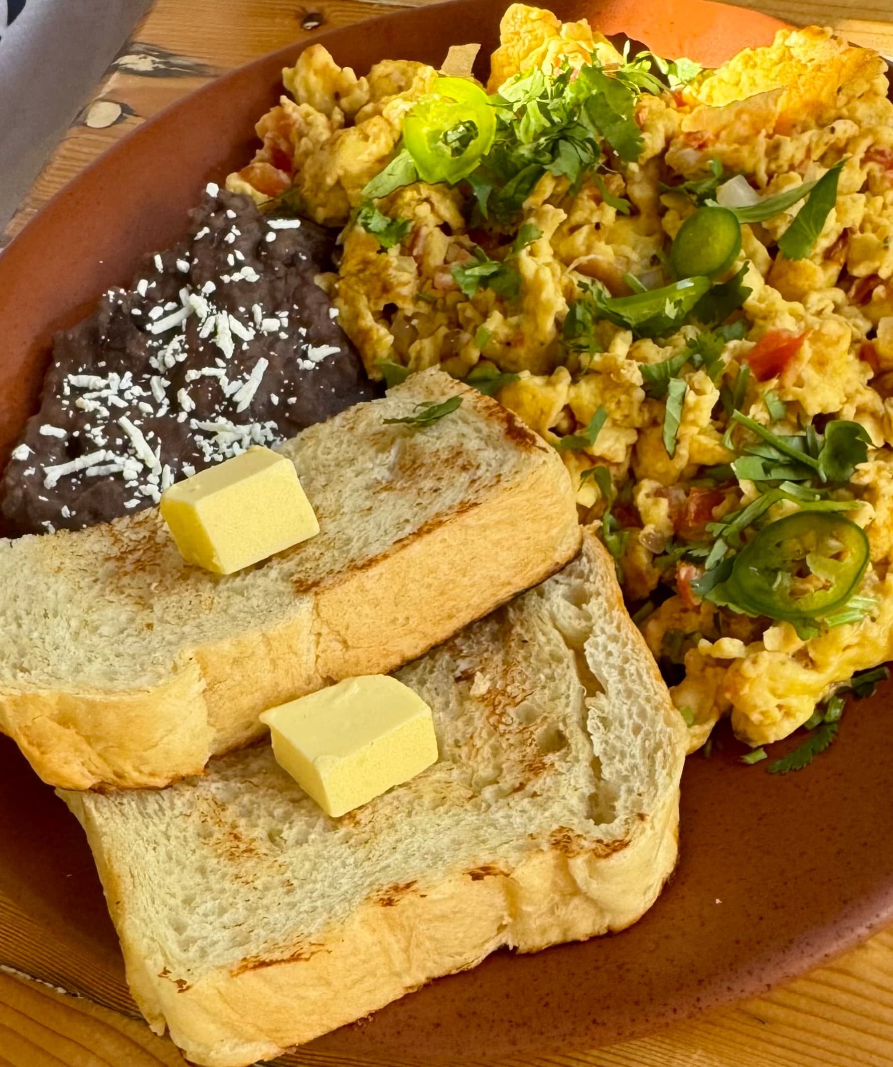 Scrambled eggs with peppers and frijoles refritos.